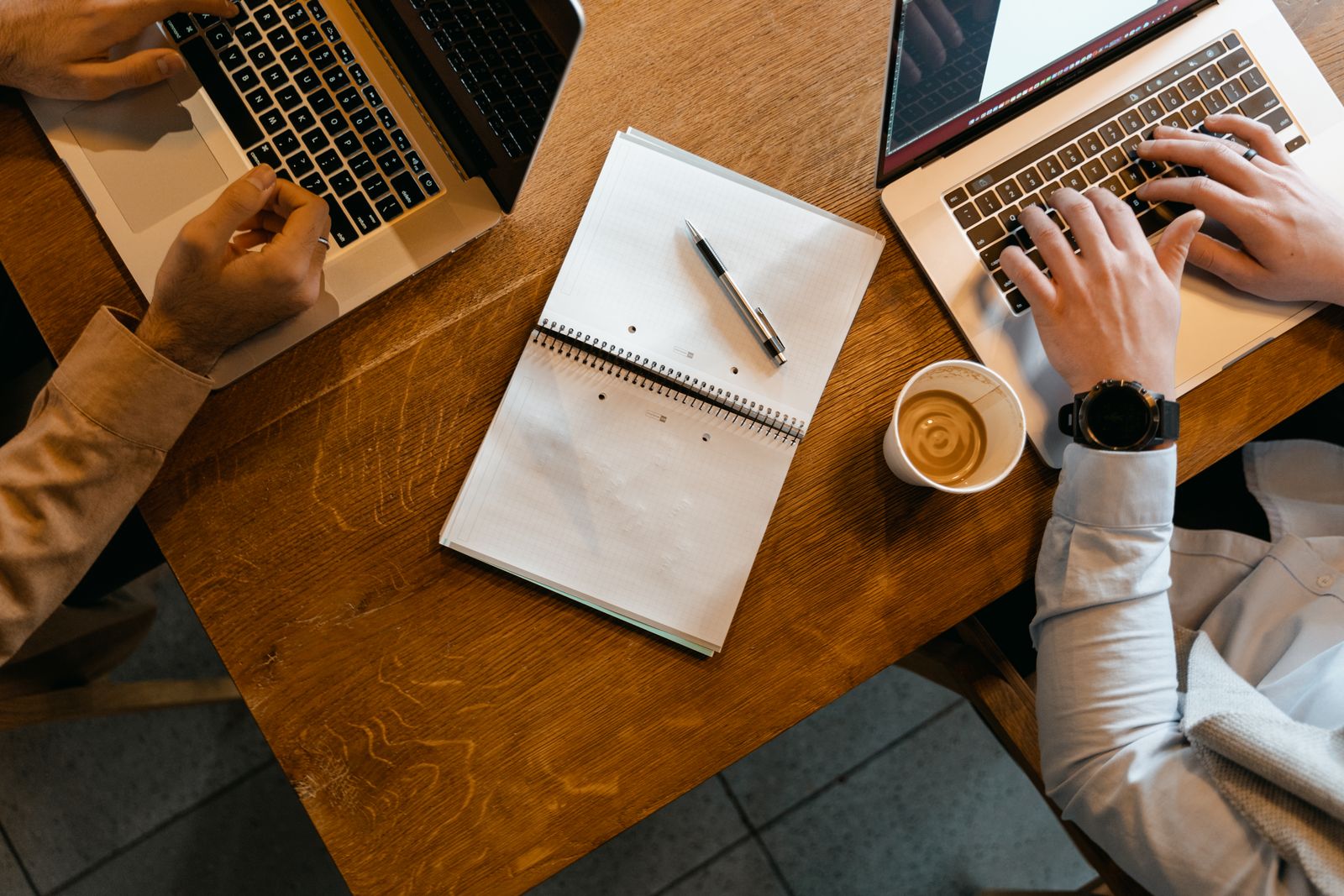 Notes and laptops on a desk while a decision gets worked through
